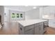 Open-concept kitchen with stainless steel appliances, gray island with quartz countertops, and light wood flooring at 1324 Parc Bench Rd, Atlanta, GA 30316