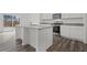 Modern kitchen with an island that includes an eat-in bar, stainless steel appliances, granite countertops and hardwood floors at 167 Silverton Dr, Dacula, GA 30019