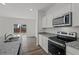 Well-lit kitchen with stainless steel appliances, granite countertops, hardwood floors, and sliding door access to the exterior at 167 Silverton Dr, Dacula, GA 30019