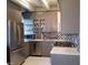 Modern kitchen features stainless steel appliances, grey cabinets, and a unique backsplash at 2479 Peachtree Ne Rd # 1115, Atlanta, GA 30305