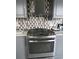 Close up of a stainless steel gas stove top and oven with custom tile backsplash at 2479 Peachtree Ne Rd # 1115, Atlanta, GA 30305