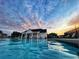 Community pool featuring a pool house and lounge chairs, all beneath a dramatic sunset sky at 5345 Coltman Dr, Cumming, GA 30028