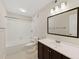 Renovated bathroom with vanity, modern lighting, and tub with white tile surround at 601 Park Ridge Cir, Marietta, GA 30068