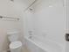 Bathroom featuring a tub with white tile surround, plus modern toilet and towel bar at 601 Park Ridge Cir, Marietta, GA 30068