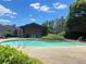 Community pool with clear water, surrounded by lush greenery and blue sky at 601 Park Ridge Cir, Marietta, GA 30068