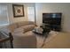 Bright living room with a unique curved couch, complemented by a stylish black coffee table, decorative art, and a large TV at 3534 S Sherwood Se Rd, Smyrna, GA 30082