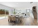Open-concept dining area with wood floors, modern table setting, flowing into a living room with a fireplace at 7176 Brushwood Bend - Lot 113, Lithonia, GA 30058