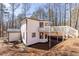 Exterior view showcasing the deck and a serene wooded backdrop with manicured landscaping and exterior AC unit at 157 Pebble Path, Douglasville, GA 30134