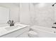 Modern bathroom with marble tile accents and a shower/tub combination, all in a clean white palette at 7685 Homer Dr, Cumming, GA 30028