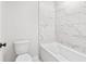 Bathroom featuring a white tub with marble-tiled backsplash at 7685 Homer Dr, Cumming, GA 30028