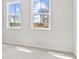 Bright bedroom featuring two large windows with views of the outdoors and plush carpet flooring at 7685 Homer Dr, Cumming, GA 30028