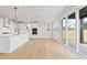 Open-concept kitchen with white cabinetry, stainless steel appliances, and sliding glass doors leading to the backyard at 7685 Homer Dr, Cumming, GA 30028