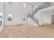 Spacious living room featuring high ceilings, large windows, a modern fireplace, and staircase access to the upper level at 7685 Homer Dr, Cumming, GA 30028