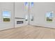 Grand living room with tall ceilings, a cozy fireplace, and multiple windows offering serene views at 7685 Homer Dr, Cumming, GA 30028