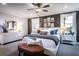 Luxurious main bedroom featuring contemporary art, two large windows, ceiling fan, and seating area at 7685 Homer Dr, Cumming, GA 30028
