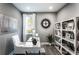 Well-lit home office with a large window, white desk, modern decor, and stylish shelving at 7685 Homer Dr, Cumming, GA 30028