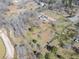 Aerial view of the home with a long driveway, pond and wooded area at 3179 Meadow Trl, Loganville, GA 30052