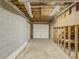 Unfinished basement featuring concrete flooring, exposed ceiling and a garage door opening to the outside at 3179 Meadow Trl, Loganville, GA 30052