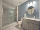 Modern bathroom with a glass-enclosed shower, round mirror and vanity with storage at 3179 Meadow Trl, Loganville, GA 30052