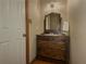 Small bathroom with a wooden vanity, sink, mirror, and white towel at 3179 Meadow Trl, Loganville, GA 30052