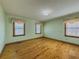 Light-filled bedroom with hardwood floors, two windows and light green walls at 3179 Meadow Trl, Loganville, GA 30052