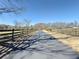 Long, paved driveway leading to the house, lined by wooden fences and trees at 3179 Meadow Trl, Loganville, GA 30052