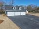 Detached three car garage with a dark gray asphalt driveway at 3179 Meadow Trl, Loganville, GA 30052