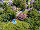 Aerial view showcases a backyard pool area and a property surrounded by mature trees at 475 Highland Gate Cir, Suwanee, GA 30024