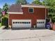 Rear exterior featuring multi-car garage, brick facade, and well-manicured landscaping, offering curb appeal at 475 Highland Gate Cir, Suwanee, GA 30024