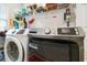 Functional laundry room with modern washer and dryer, shelving and storage, plus bright lighting at 475 Highland Gate Cir, Suwanee, GA 30024