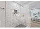 Contemporary shower with large white tiles, gold fixtures, niche, and gray tile floor at 1995 Venetian Sw Dr, Atlanta, GA 30311