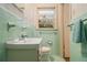 Bathroom with a window, a green tile countertop sink, and a towel rack at 2436 Hazelwood Ne Dr, Atlanta, GA 30345