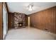 Spacious living room featuring a fireplace, wood paneling, and a ceiling fan at 2436 Hazelwood Ne Dr, Atlanta, GA 30345