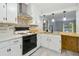 Well-lit kitchen featuring white cabinets, stylish backsplash, and stainless steel appliances at 4053 Overland Trl, Snellville, GA 30039