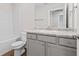 Bathroom featuring a shower-tub combination, toilet, and a vanity with granite countertops and grey cabinets at 11204 Cornerstone Way, Hampton, GA 30228