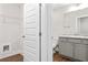Clean bathroom with vanity, toilet and wire shelf behind a five panel door at 11204 Cornerstone Way, Hampton, GA 30228