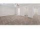 Large carpeted bedroom with neutral walls, a ceiling fan, and open closet and doorway, offering lots of potential at 11204 Cornerstone Way, Hampton, GA 30228