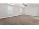 Spacious bedroom featuring soft carpeting, a ceiling fan, and two large windows for plenty of natural light at 11204 Cornerstone Way, Hampton, GA 30228