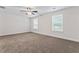 Bright bedroom features two large windows, neutral walls, soft carpeting, and ceiling fan with light at 11204 Cornerstone Way, Hampton, GA 30228
