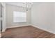 Bright dining room with modern chandelier, large window and dark wood floors at 11204 Cornerstone Way, Hampton, GA 30228