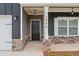 Inviting front entry with stylish stone accents, pendant lights, and a modern black door at 11204 Cornerstone Way, Hampton, GA 30228