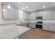 Modern kitchen featuring granite countertops, stainless appliances, and gray cabinets at 11204 Cornerstone Way, Hampton, GA 30228