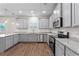 Modern kitchen featuring gray cabinetry, stainless steel appliances, and granite countertops at 11204 Cornerstone Way, Hampton, GA 30228
