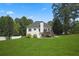 Lovely back exterior features a deck, a chimney, and a sprawling lawn at 136 Huntcliff Trl, Ellenwood, GA 30294