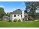 Spacious backyard with lush grass, deck, and charming architecture at 136 Huntcliff Trl, Ellenwood, GA 30294