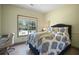 Serene bedroom with a cozy bed, desk, and a large window overlooking the yard at 136 Huntcliff Trl, Ellenwood, GA 30294