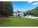 A beautifully landscaped front yard leads to a pristine white home, creating a welcoming and picturesque scene at 136 Huntcliff Trl, Ellenwood, GA 30294