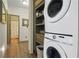 Stackable washer and dryer in a laundry space with an open door to the bathroom at 136 Huntcliff Trl, Ellenwood, GA 30294