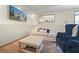 Comfortable living room features a plush white sofa, blue chairs, and an ottoman at 136 Huntcliff Trl, Ellenwood, GA 30294