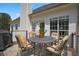 Exterior shot of outdoor dining space on a patio with a table and cushioned chairs at 136 Huntcliff Trl, Ellenwood, GA 30294